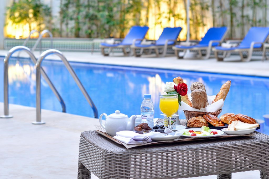 pexels-photo-19239909-19239909 Indulgent breakfast by a poolside with fresh pastries and juice.