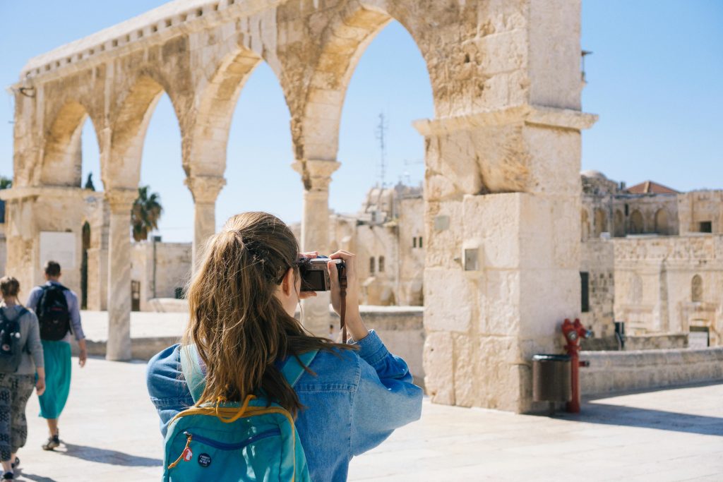 pexels-photo-2087391-2087391 A tourist photographs the ancient stone arches in Jerusalem's Old Town, capturing the essence of travel and history.